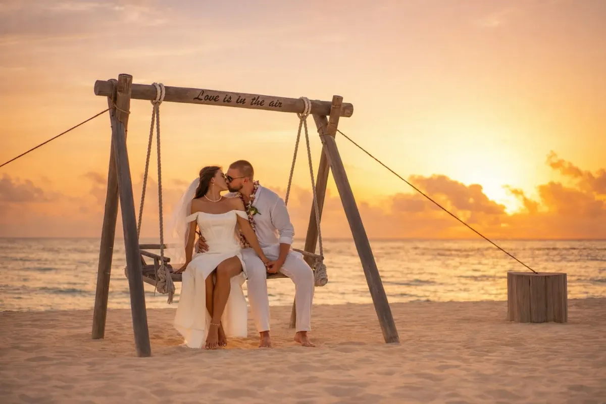 Wedding couple on a swing at sunset in the Maldives